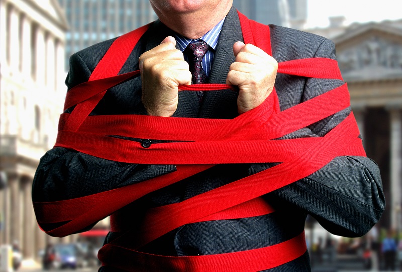Businessman bound up in red tape, mid section, close-up